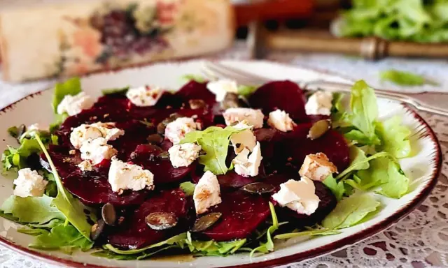 Pyszne carpaccio z buraka z serem feta, rukolą i pestkami dyni na talerzu.