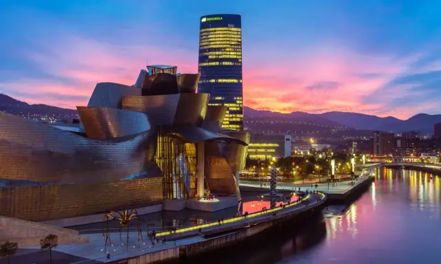 Zachód słońca nad rzeką w Euskadi, z Muzeum Guggenheima i wieżowcem Iberdrola w tle.