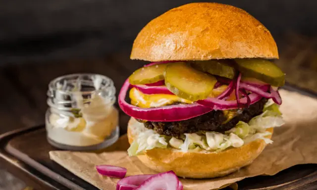 Pyszny burger z soczystą wołowiną, chrupiącą sałatą, piklami, czerwoną cebulą i majonezem. Idealny na prawdziwe burgery przepis.