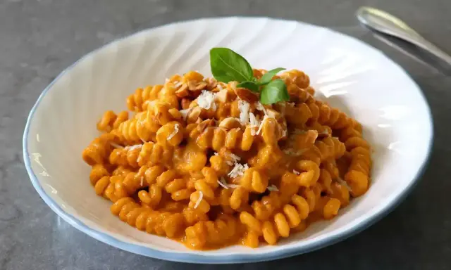 Pyszny makaron fusilli w kremowym sosie pomidorowym, posypany parmezanem i orzeszkami. Idealny makaron na obiad.
