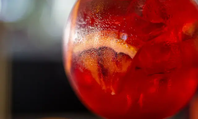 Orzeźwiający Martini Fiero drink z lodem i plasterkiem pomarańczy, skraplający się od zimna.