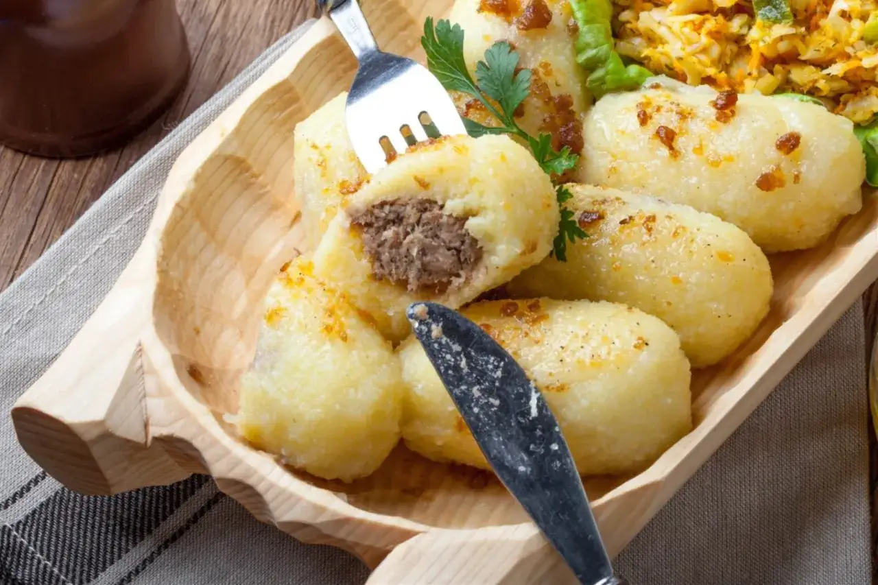 Kartacze z mięsem, jak u babci! Pyszne, ziemniaczane kluski z farszem, podane w drewnianej misie.