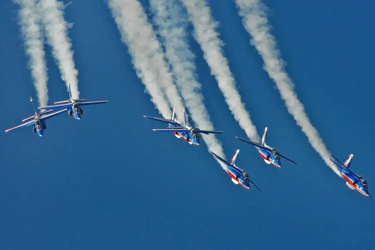 Samoloty akrobacyjne podczas Air Show w Radomiu malują niebo białymi smugami.