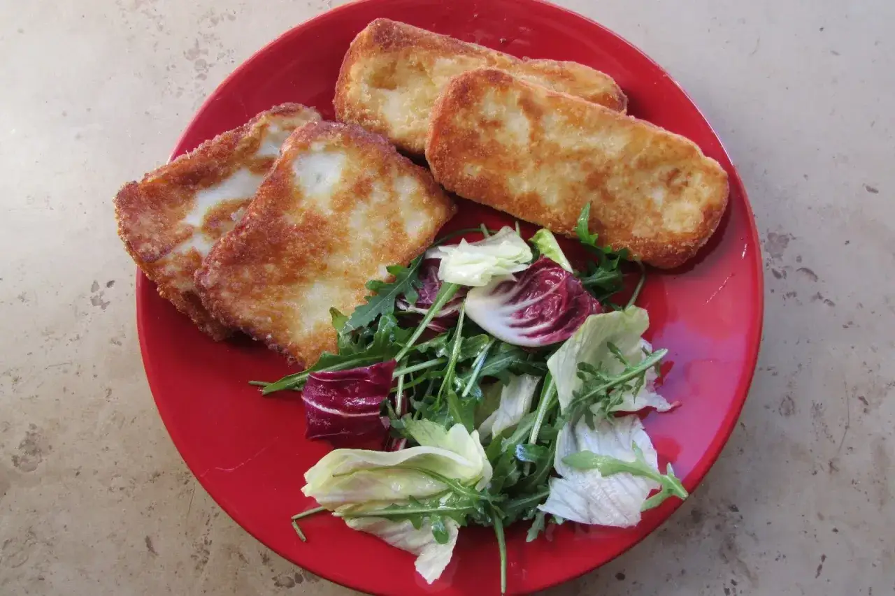 Smażony ser halloumi z sałatką na czerwonym talerzu. Prosty halloumi przepis na szybki obiad.
